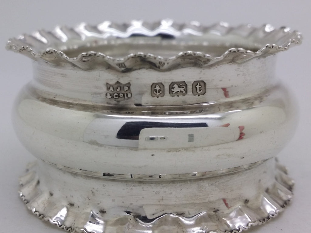 Napkin ring hallmarks: A J Pepper & Co maker's mark AJP&COLD; anchor mark for Birmingham; lion passant mark for sterling silver; and Birmingham date letter t for 1918.