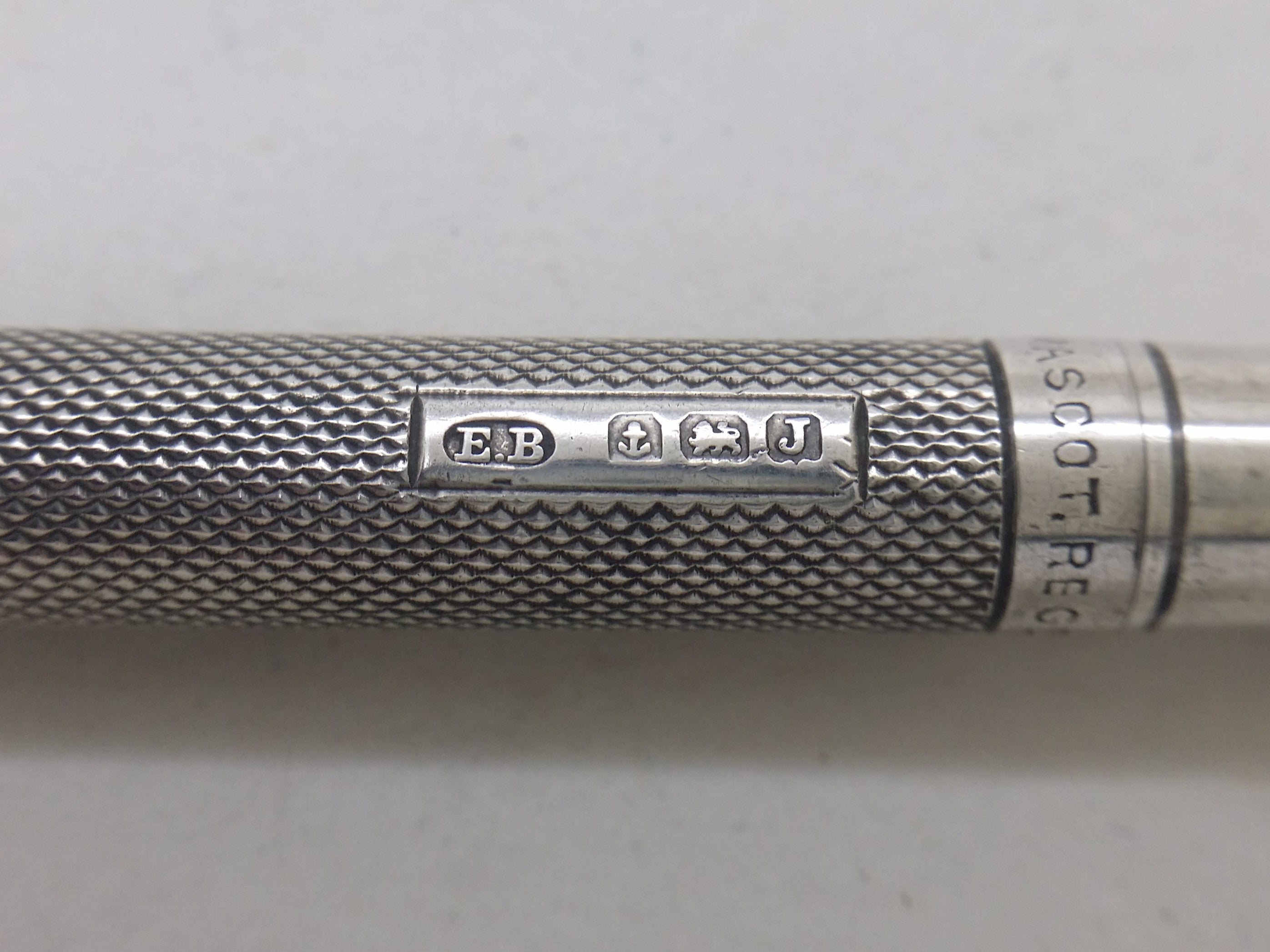 Propelling pencil hallmarks: Edward Baker & Son maker's mark EB; anchor mark for Birmingham; lion passant mark for sterling silver; and Birmingham date letter J for 1933.