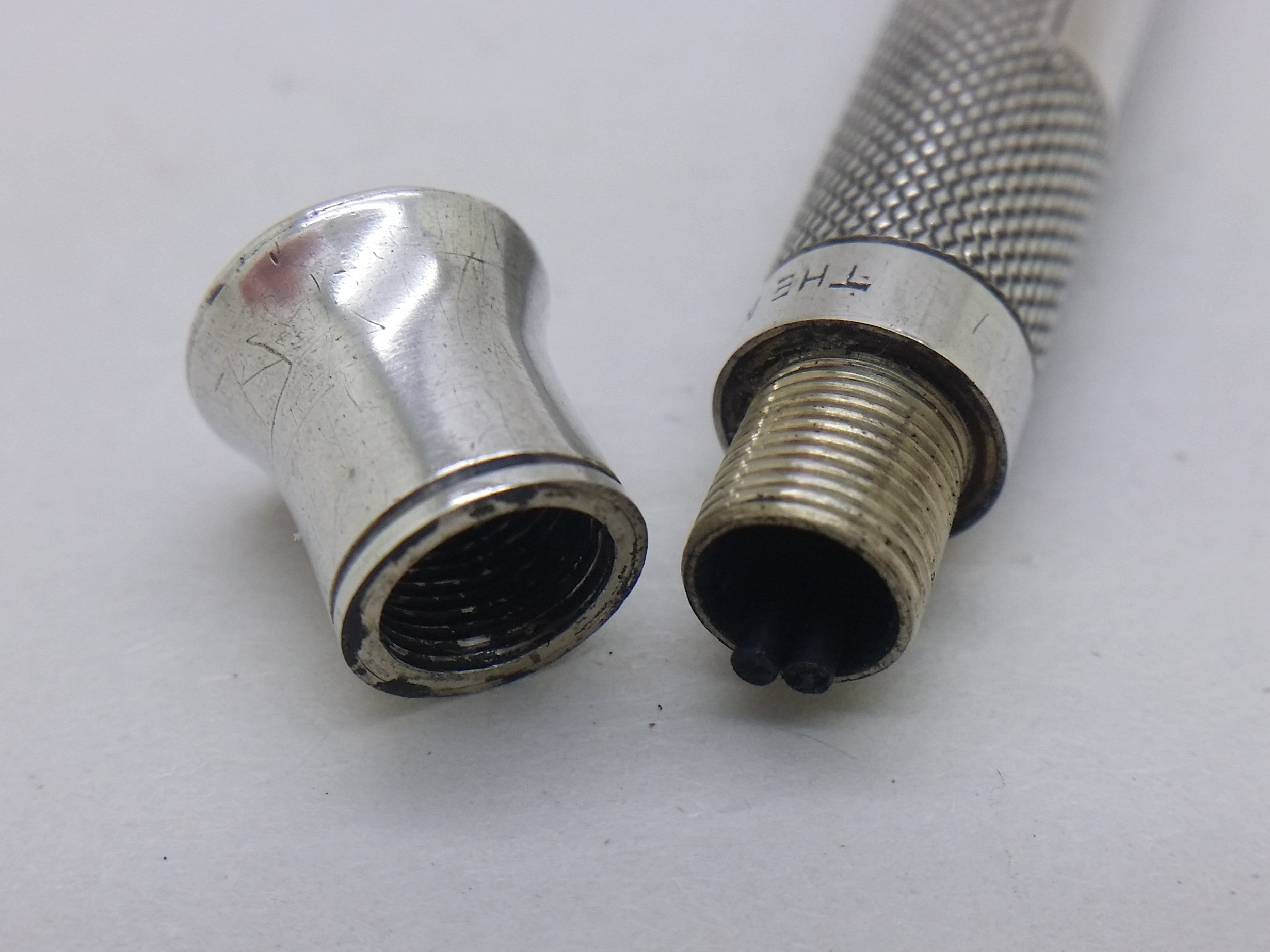 Screw-fit endcap removed from sterling silver "The Mascot" propelling pencil, showing spare pencil leads