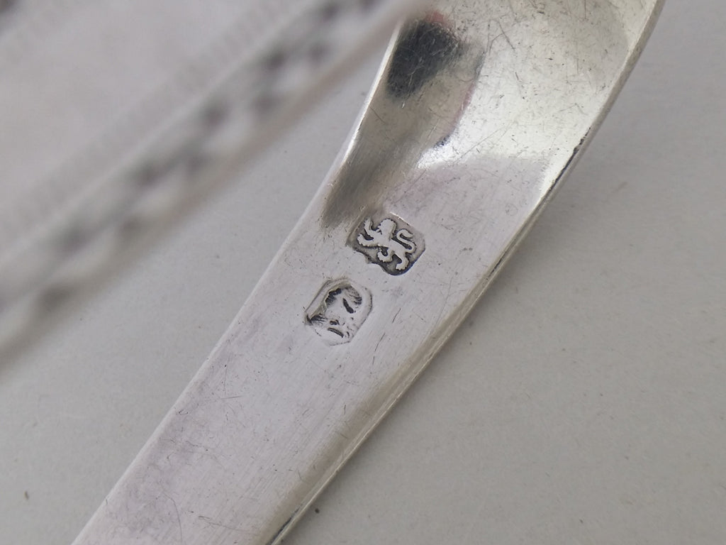 Sugar tongs simplified hallmarks: lion passant mark for sterling silver; and the George III incuse duty mark.
