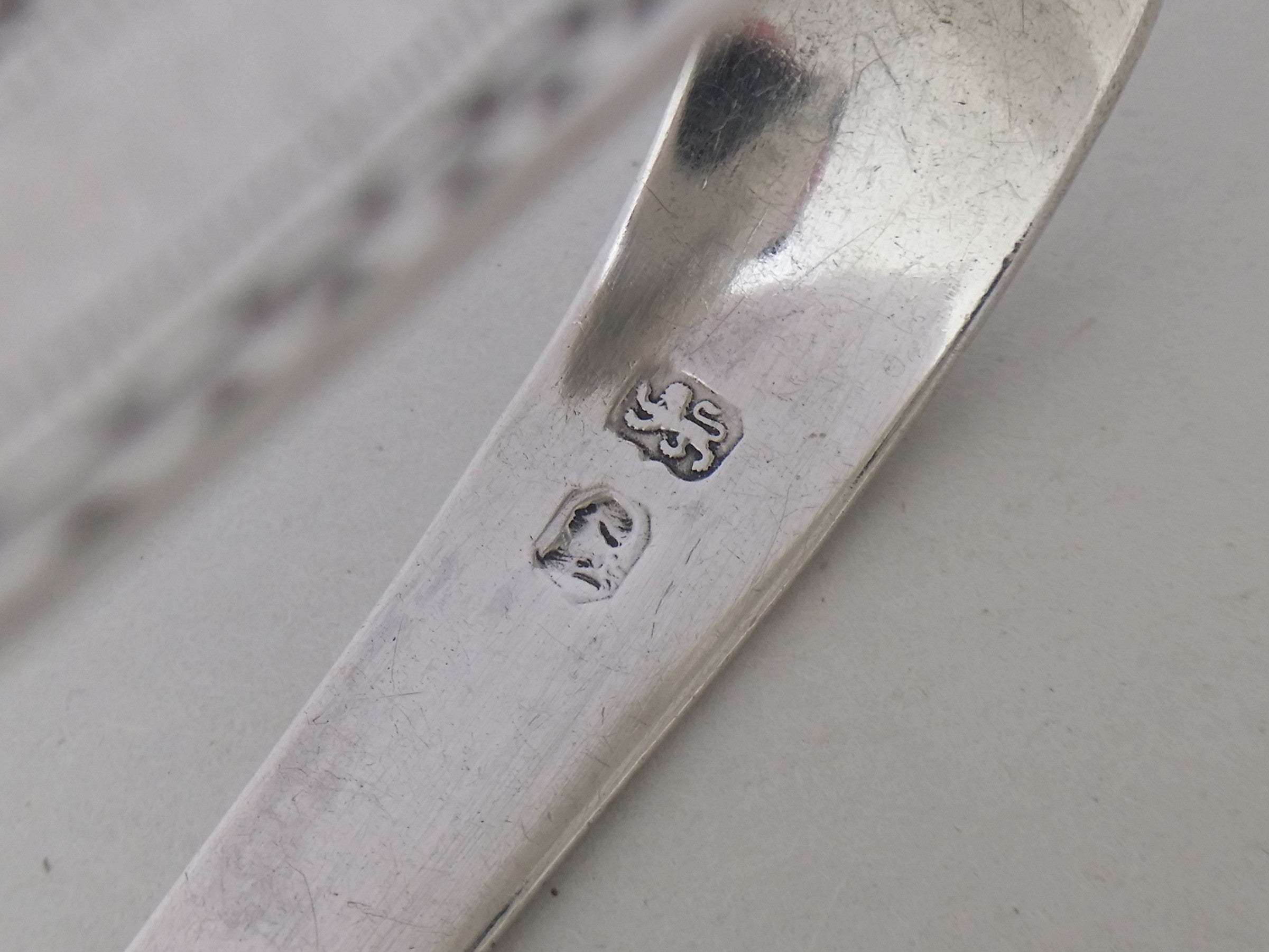 Sugar tongs simplified hallmarks: lion passant mark for sterling silver; and the George III incuse duty mark.