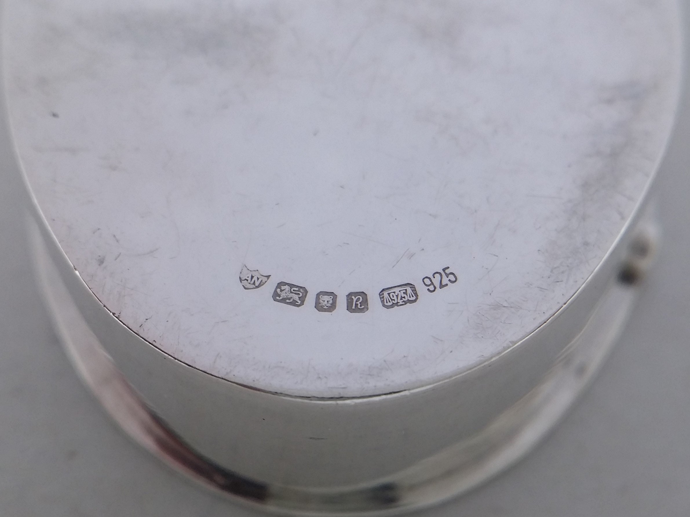 Pill box hallmarks: Ari D Norman maker's mark AN; lion passant mark for sterling silver; leopard head mark for London; UK date letter R for 1991; common control mark; and 925 mark.