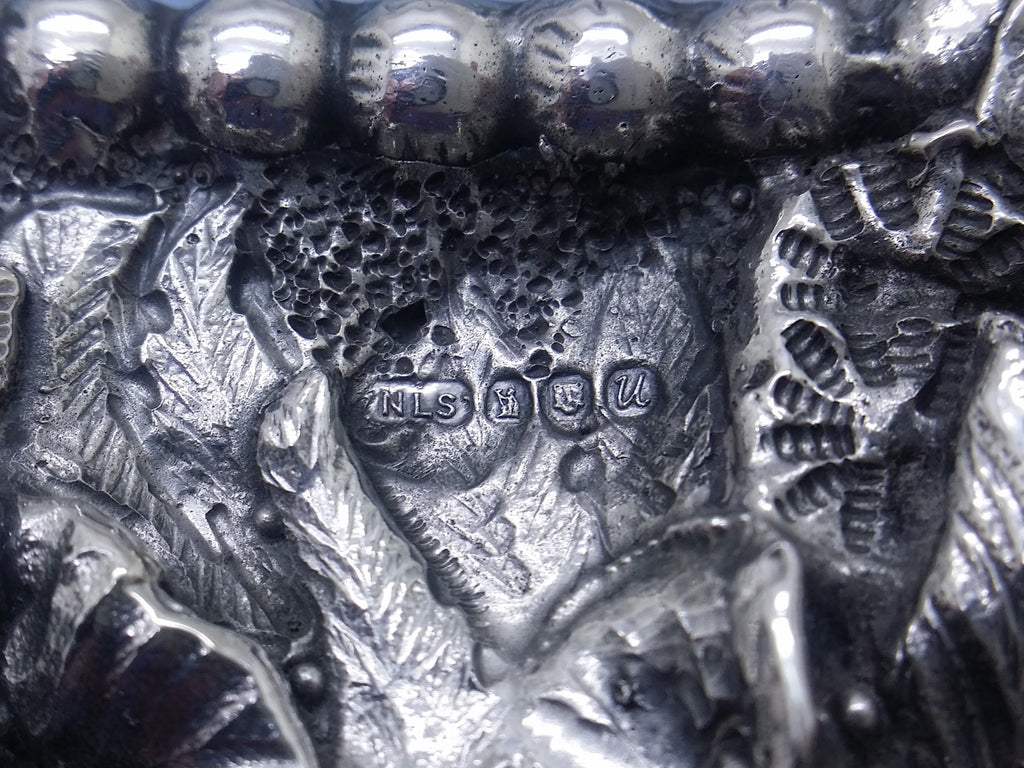 Photo frame hallmarks: Neil Lasher Silverware maker's mark NLS; Britannia mark for 958 britannia silver; leopard head mark for London; and UK date letter U for 1994.