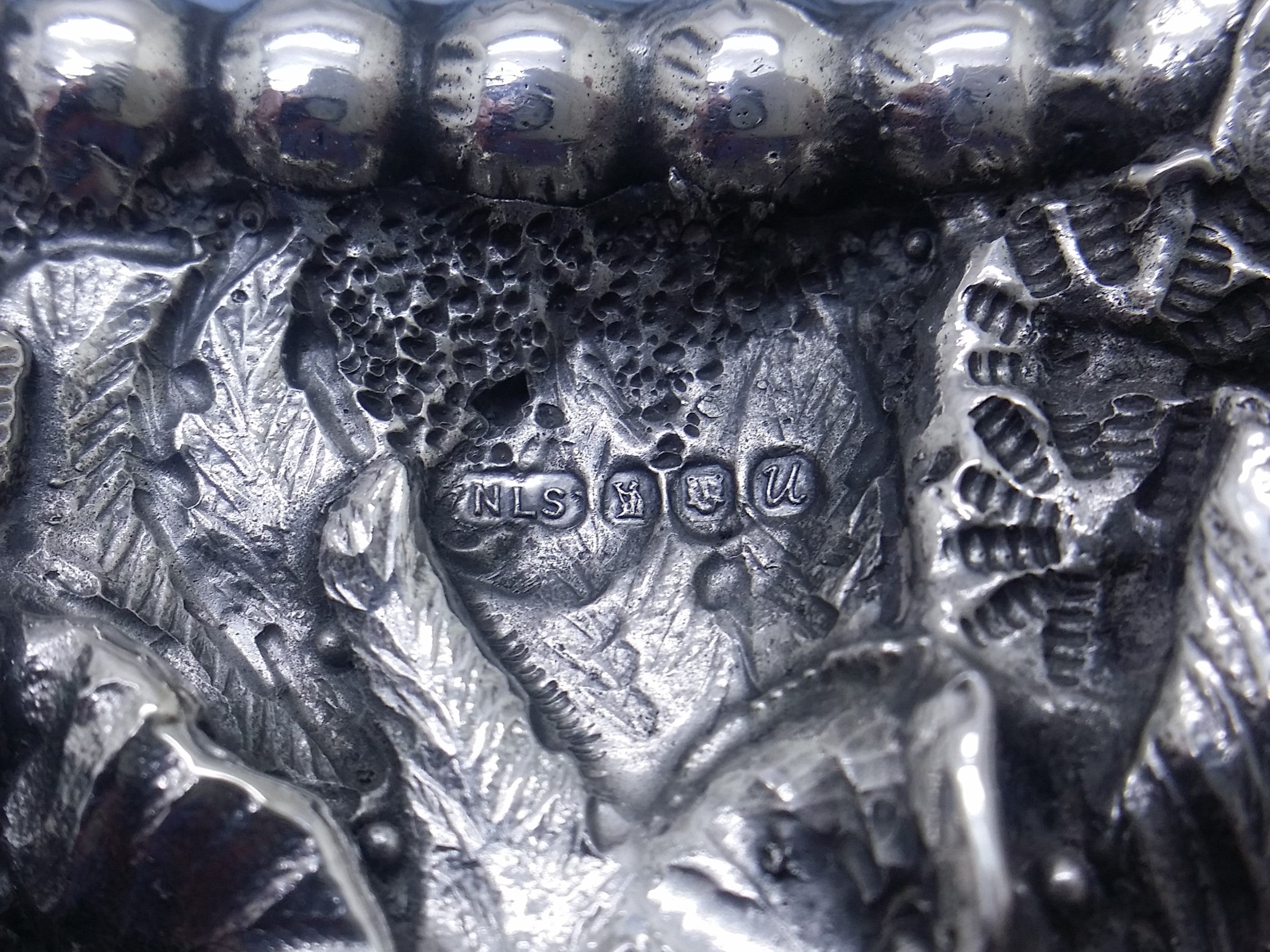 Photo frame hallmarks: Neil Lasher Silverware maker's mark NLS; Britannia mark for 958 britannia silver; leopard head mark for London; and UK date letter U for 1994.