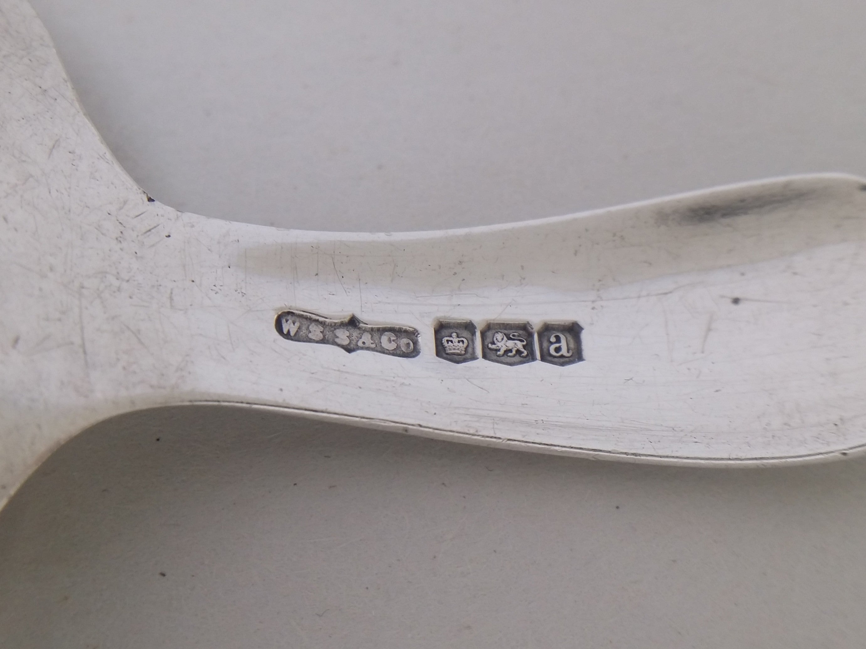 Caddy spoon hallmarks: W S Savage & Co maker's mark WSS&CO; crown mark for Sheffield; lion passant mark for sterling silver; and Sheffield date letter a for 1918.