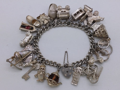 Elizabeth II 1969 sterling silver charm bracelet with 29 charms, Birmingham by Clarke Brothers (Liverpool) Ltd