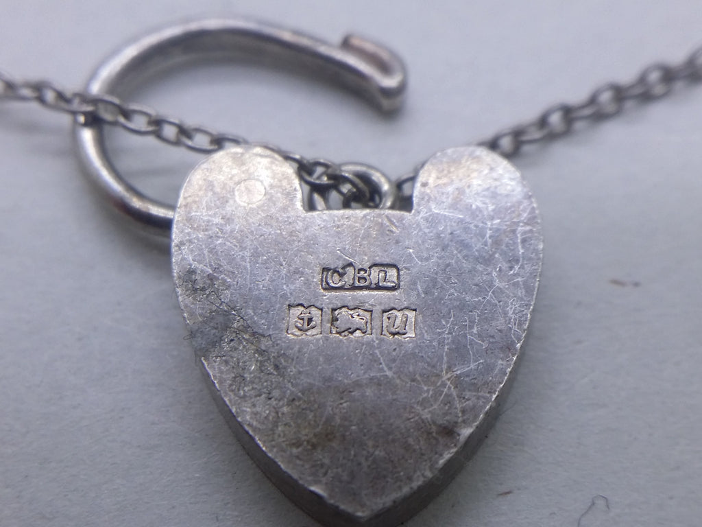 Charm bracelet padlock hallmarks: Clarke Brothers (Liverpool) Ltd maker's mark CBL; anchor mark for Birmingham; lion passant mark for sterling silver; and Birmingham date letter U for 1969.