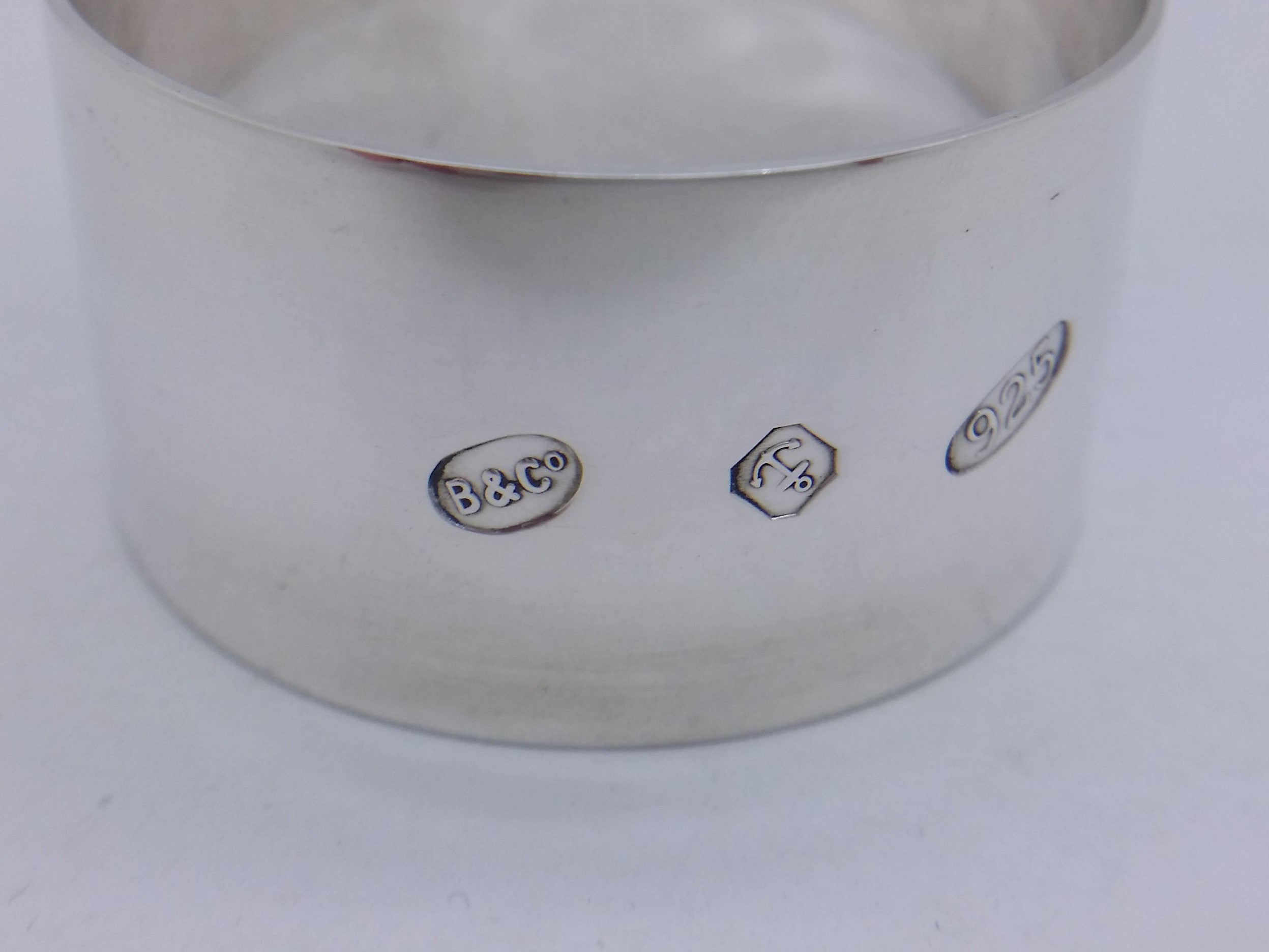 Napkin ring hallmarks: Broadway & Co maker's mark B&CO; anchor mark for Birmingham; and 925 mark for sterling silver.