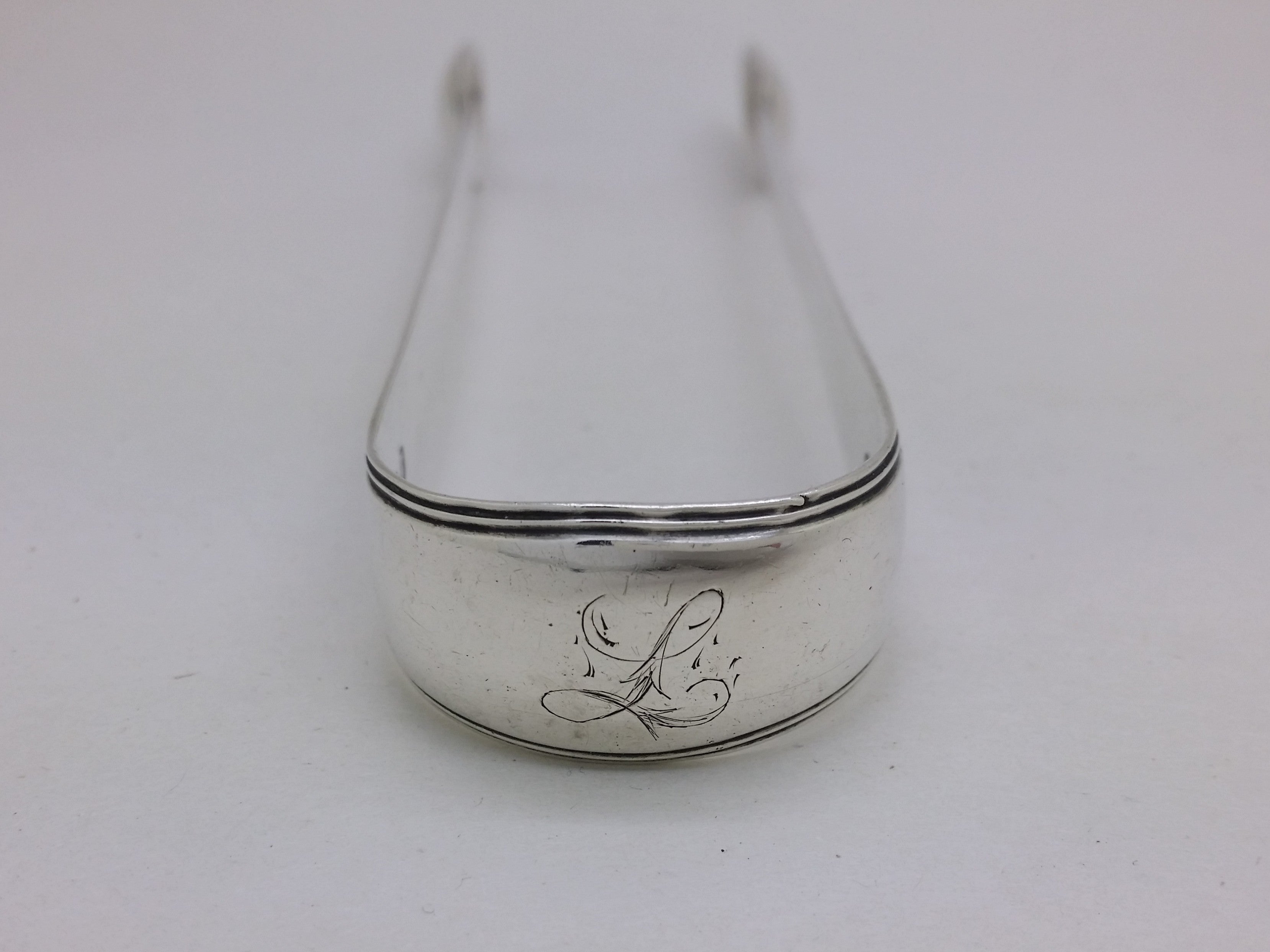 Bow of sterling silver sugar tongs with initial inscription L