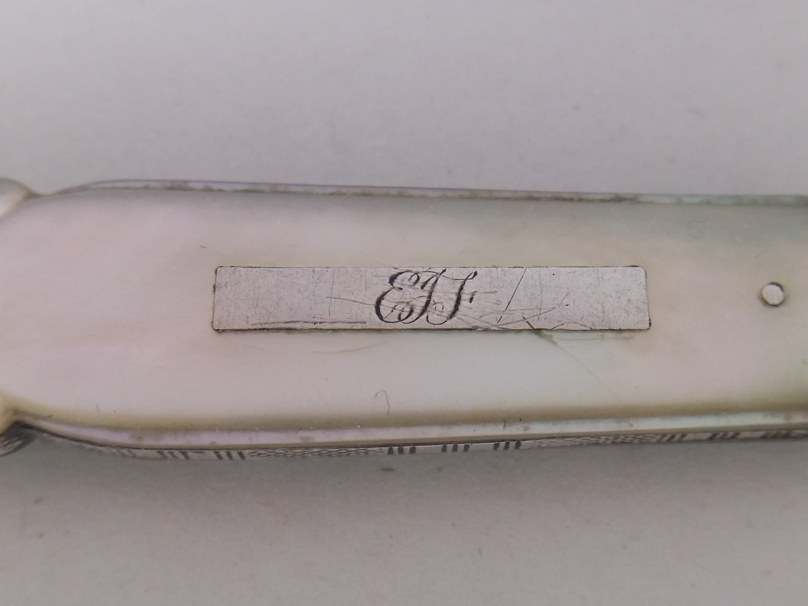 EJF or EIF initial engraved cartouche on a mother or pearl fruit knife handle