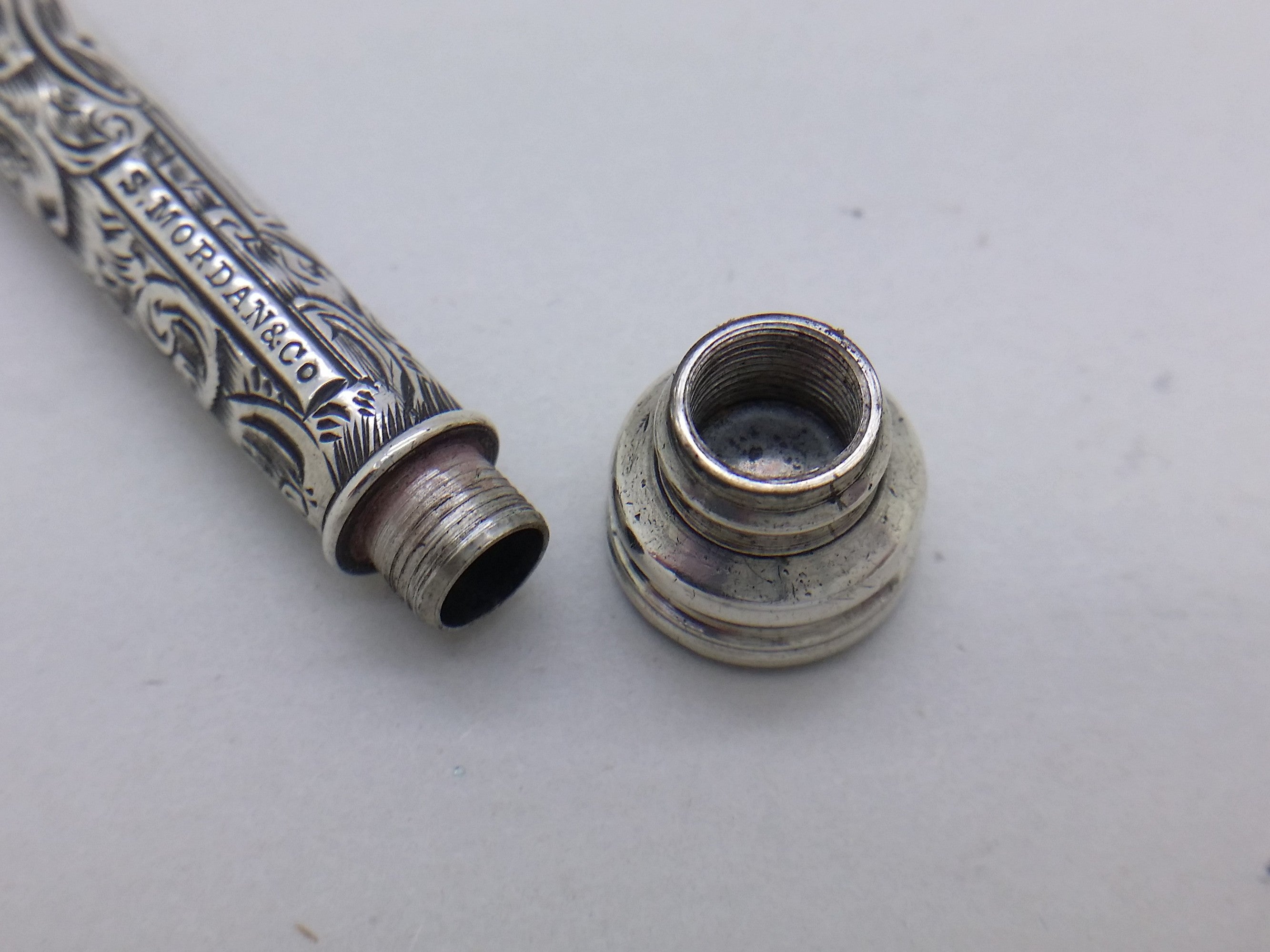 Screw-fit terminal endcap removed from Sampson Mordan propelling pencil, empty but showing where spare pencil leads would be stored.