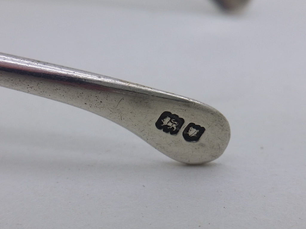 Sugar tongs supplemental hallmarks: lion passant mark for sterling silver; and leopard head mark for London.