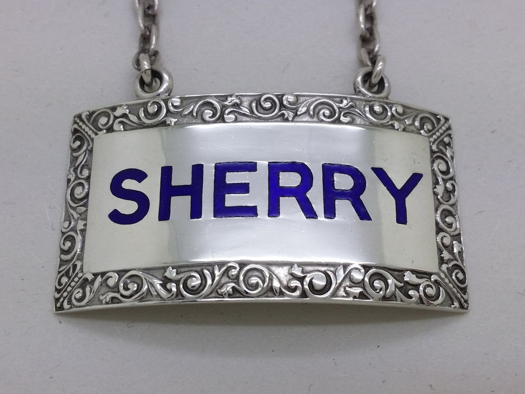 Close-up of the decanter label, showing the dark blue enamel filled letters SHERRY, and foliate scrolled border.