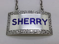 Close-up of the decanter label, showing the dark blue enamel filled letters SHERRY, and foliate scrolled border.
