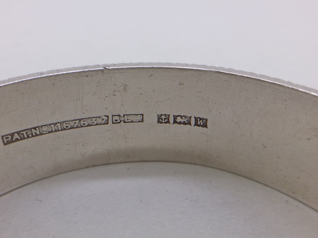 Hinged bangle hallmarks: British Pat.No.1167637 attributed to Bracelon Ltd; Bracelon Ltd maker's mark BLTD; anchor mark for Birmingham; lion passant mark for sterling silver; and Birmingham date letter W for 1971.