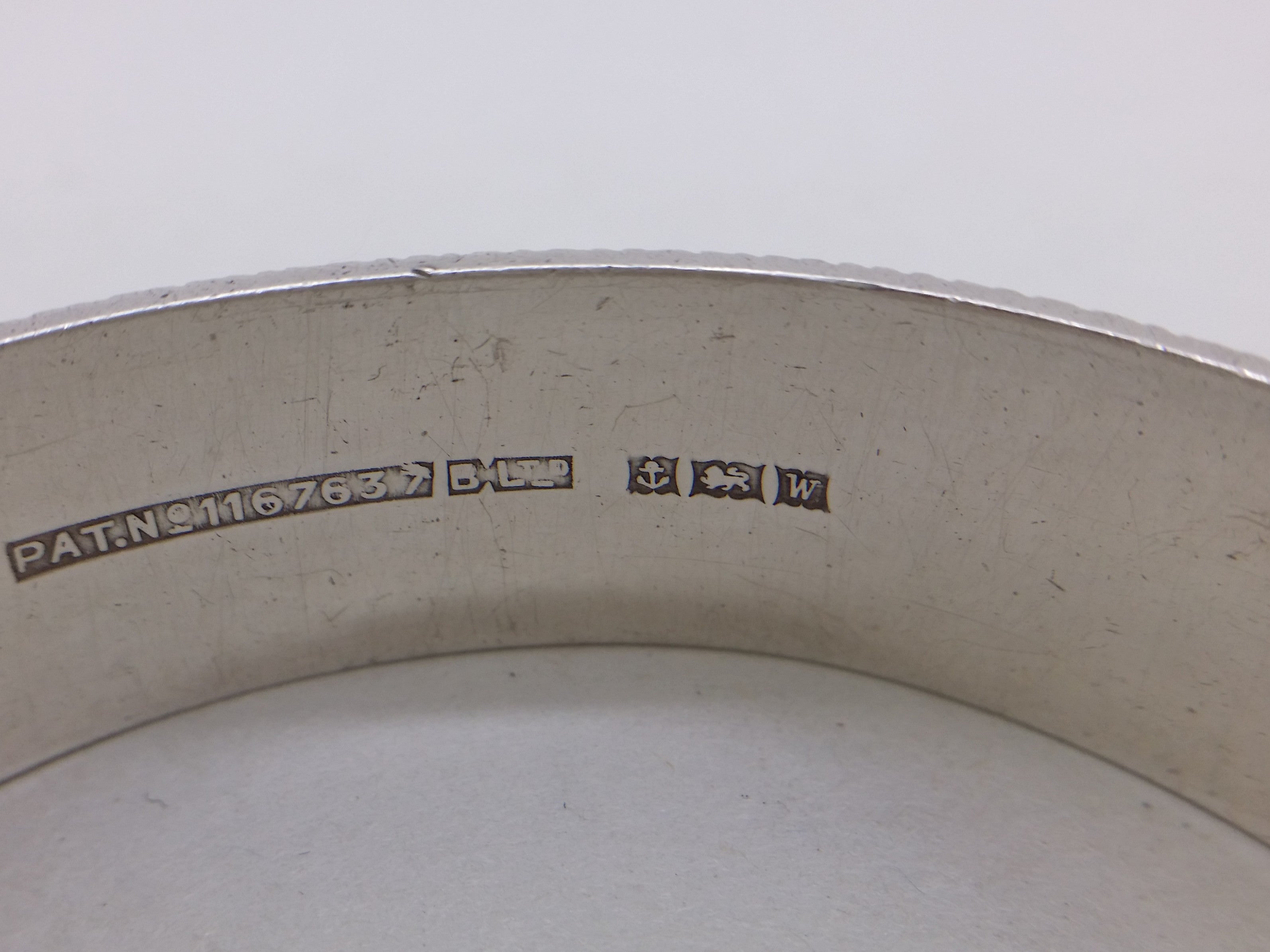 Hinged bangle hallmarks: British Pat.No.1167637 attributed to Bracelon Ltd; Bracelon Ltd maker's mark BLTD; anchor mark for Birmingham; lion passant mark for sterling silver; and Birmingham date letter W for 1971.
