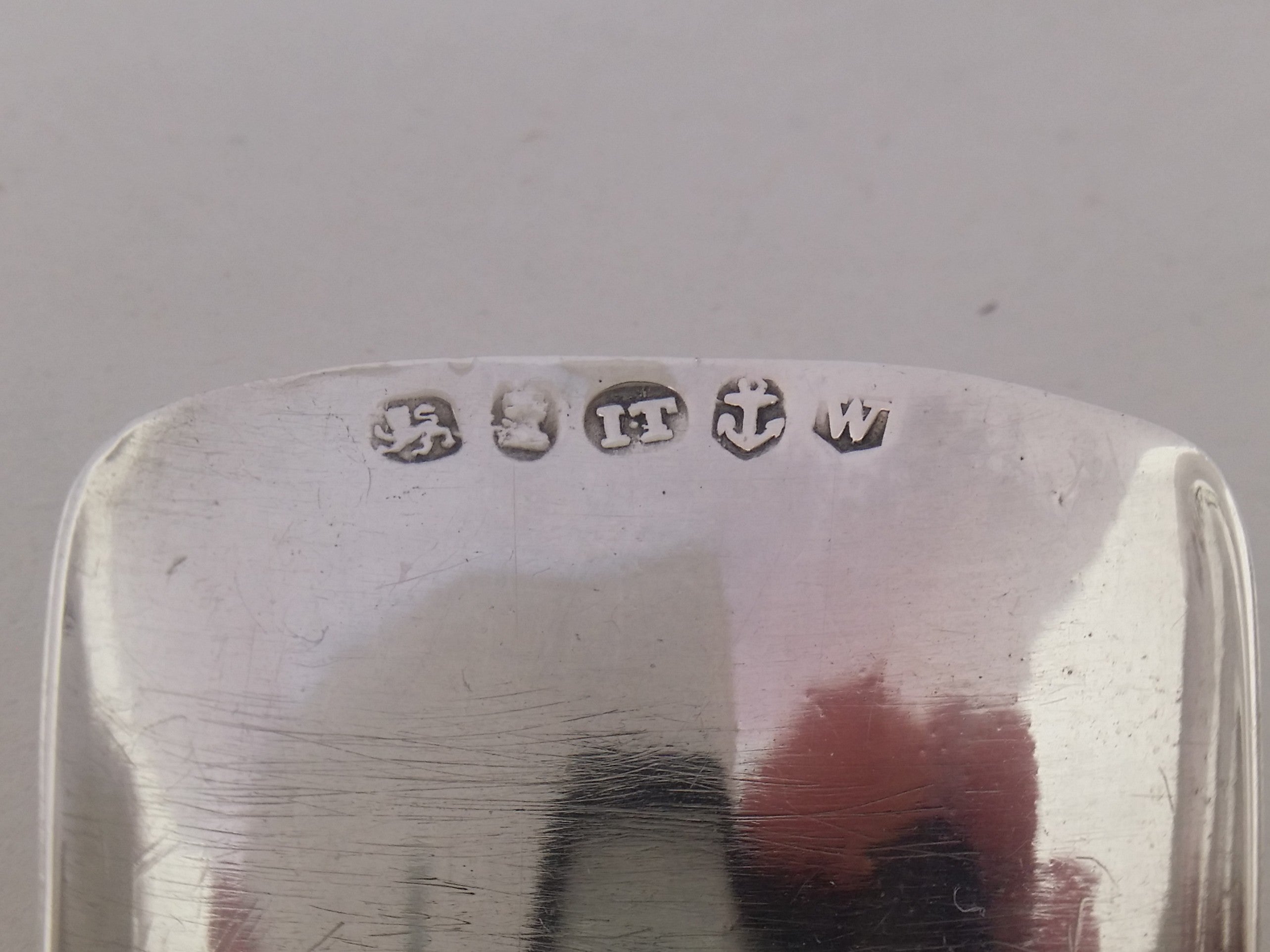 Caddy spoon hallmarks: lion passant mark for sterling silver; George III duty mark; Joseph Taylor maker's mark IT; anchor mark for Birmingham; Birmingham date letter w for 1820.